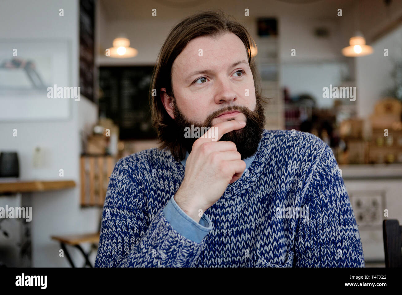 Homme avec barbe, assis dans un café, portrait Banque D'Images