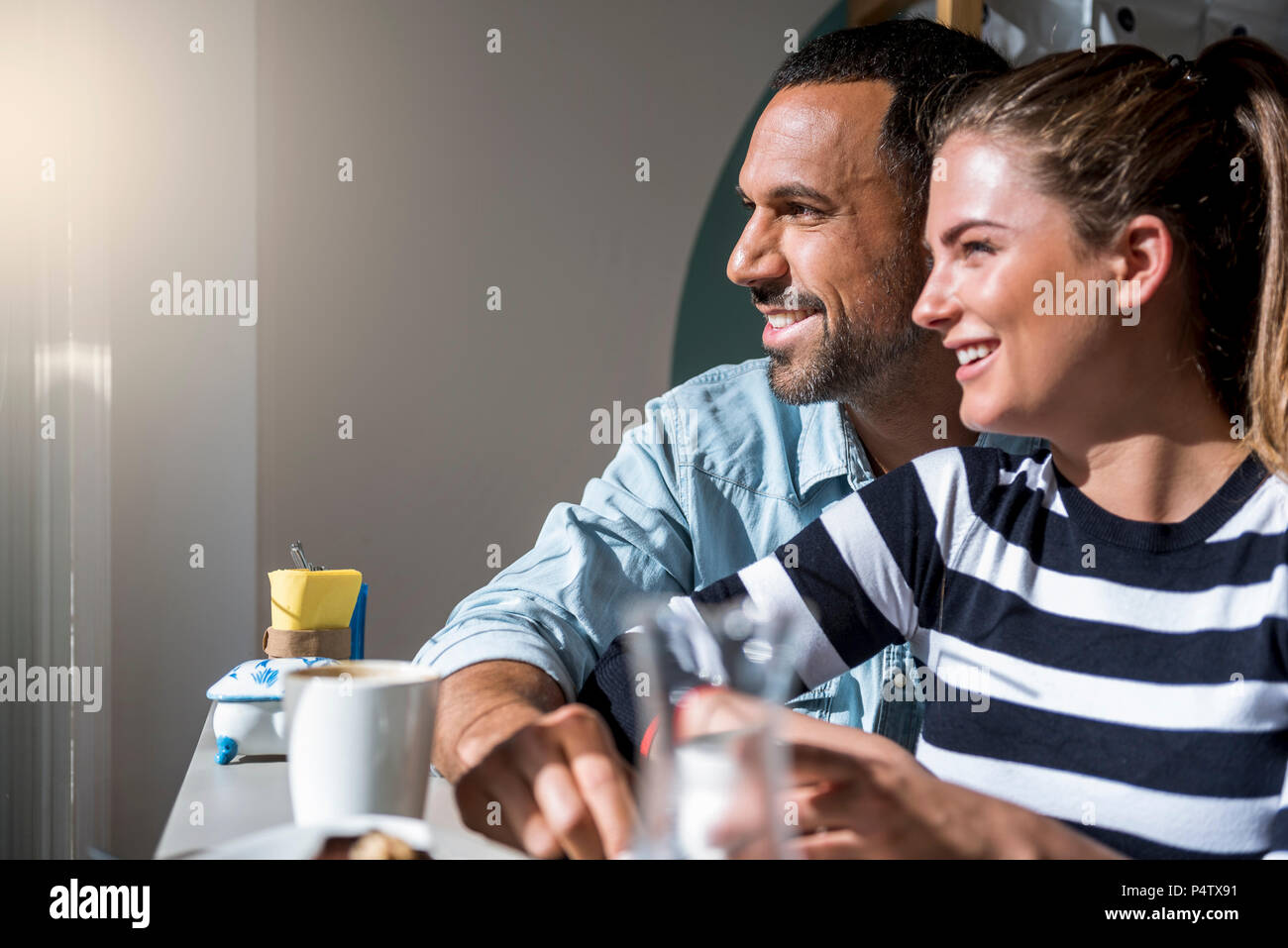 Heureux couple dans un café à la fenêtre de Banque D'Images