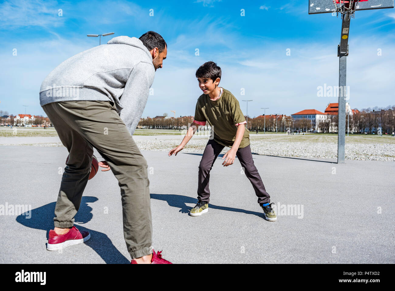 Père et fils jouer au basket-ball sur l'extérieur de la cour Banque D'Images Père et fils jouer au basket-ball sur l'extérieur de la cour Banque D'Images