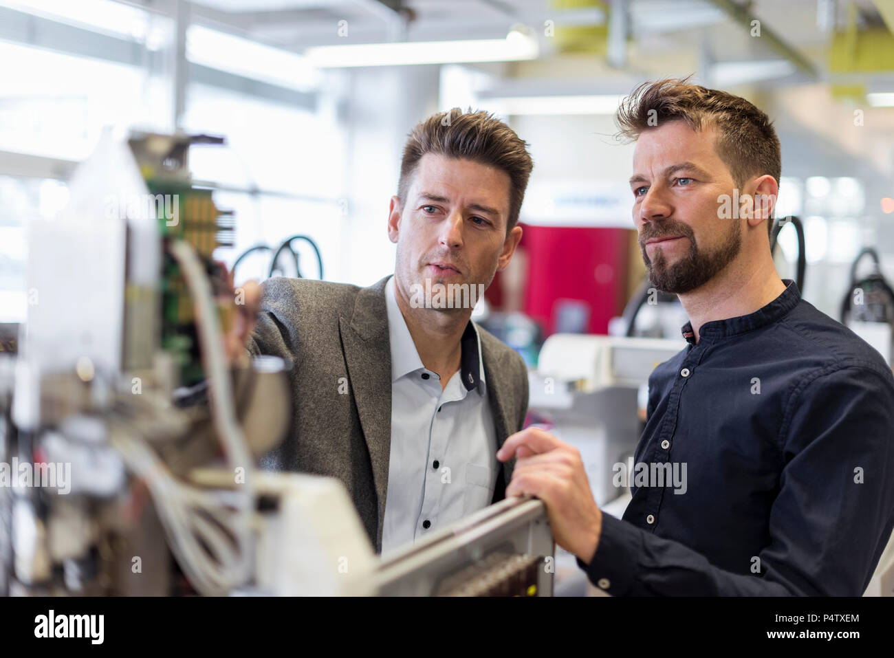 Deux hommes d'examiner en usine de l'appareil Banque D'Images