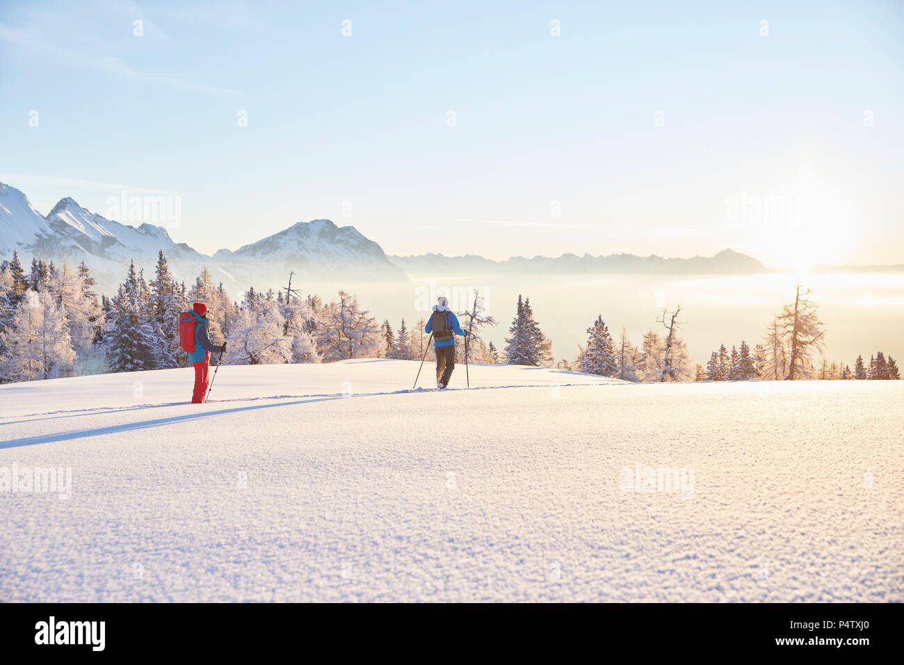 Autriche, Tyrol, randonneurs en raquettes au lever du soleil Banque D'Images