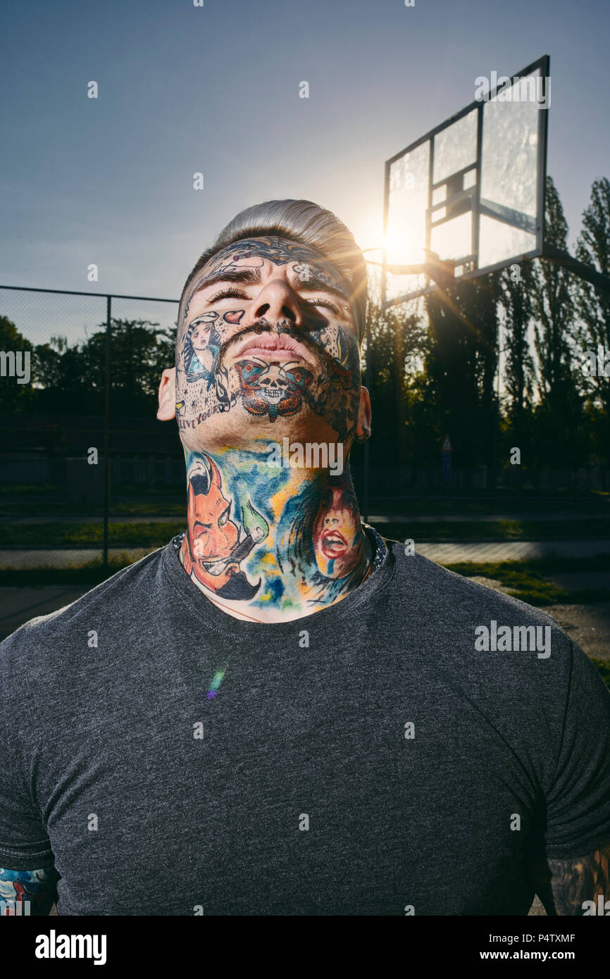 Portrait de jeune homme tatoué sur le terrain de basket-ball Banque D'Images