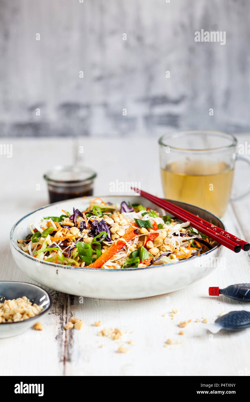 Avec salade de pâtes de verre, choux, carottes, poivrons, oignons de printemps, d'arachide et de vinaigrette thaï chaude Banque D'Images