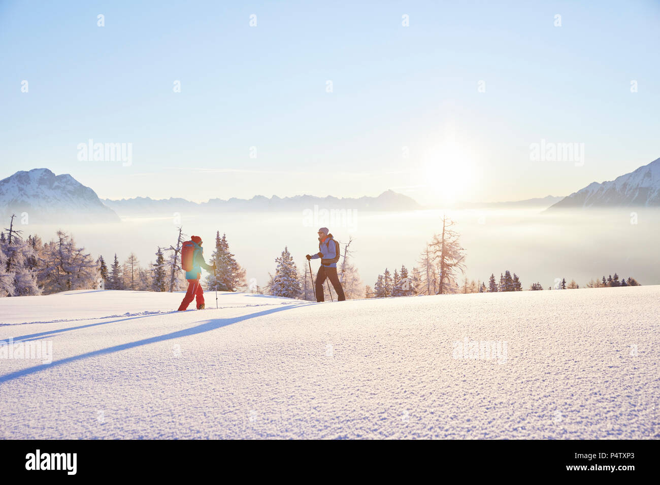 Autriche, Tyrol, randonneurs en raquettes au lever du soleil Banque D'Images