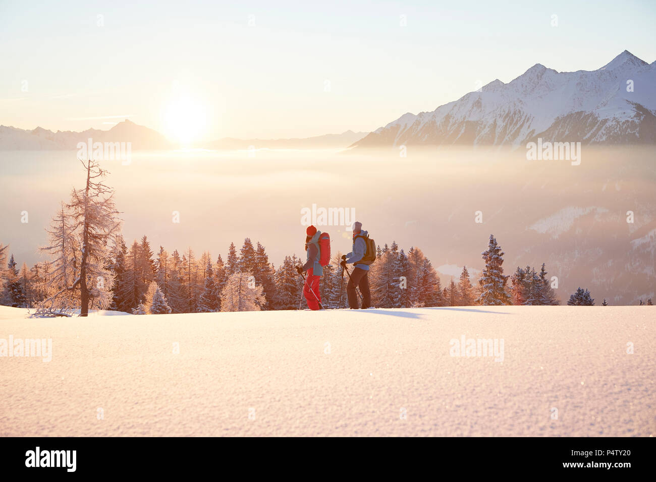 Autriche, Tyrol, randonneurs en raquettes au lever du soleil Banque D'Images