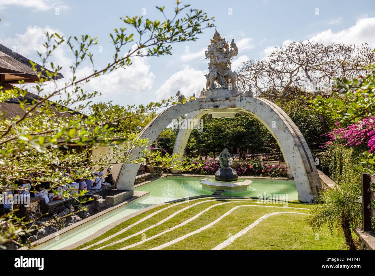 Cérémonies à Pura Luhur Uluwatu, Balinais traditionnel hindou assis dans une balle près de la statue d'un singe. Bali, Indonésie Banque D'Images