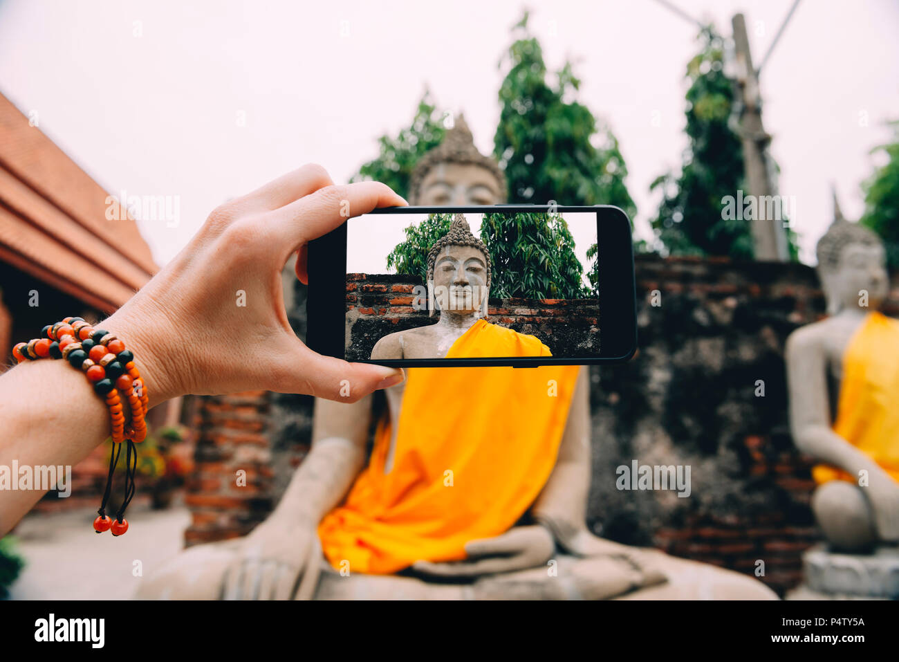 La Thaïlande, Ayutthaya, Wat Yai Chai Mongkhon, prendre une photo de Bouddha avec smartphone Banque D'Images