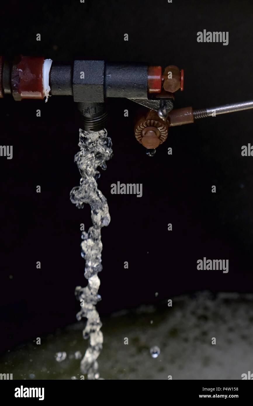 L' eau découlant d'une soupape à flotteur dans un réservoir Photo