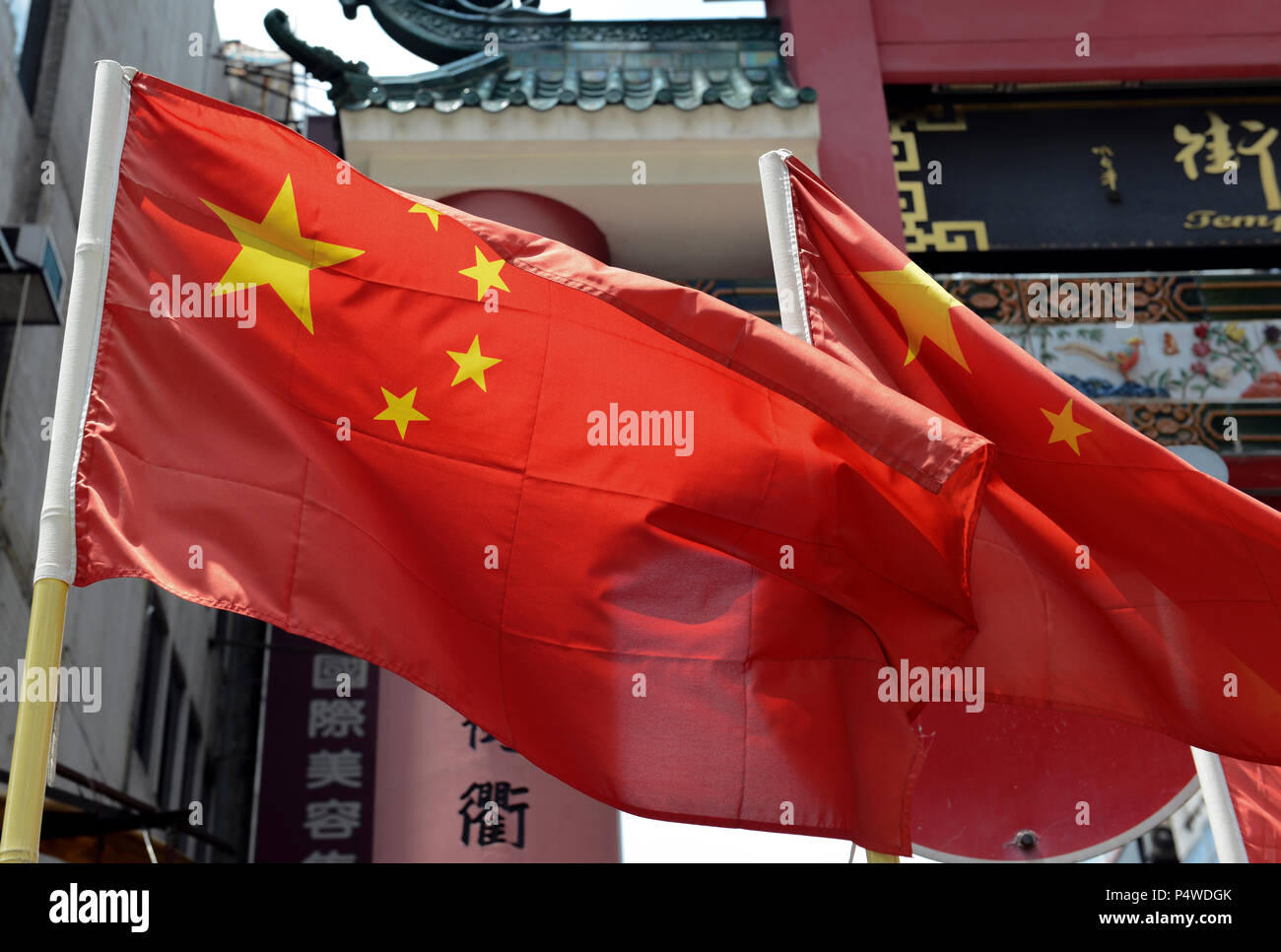 Drapeau chinois avec un texte disant Temple Street et service de change en arrière-plan, Hong Kong, Chine Banque D'Images