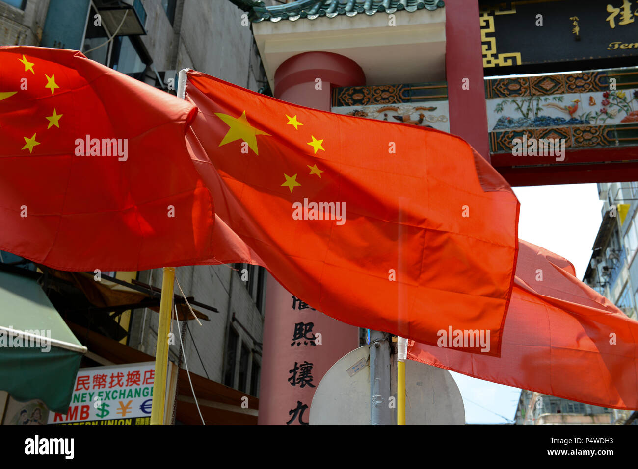 Drapeau chinois avec un texte disant Temple Street et service de change en arrière-plan, Hong Kong, Chine Banque D'Images