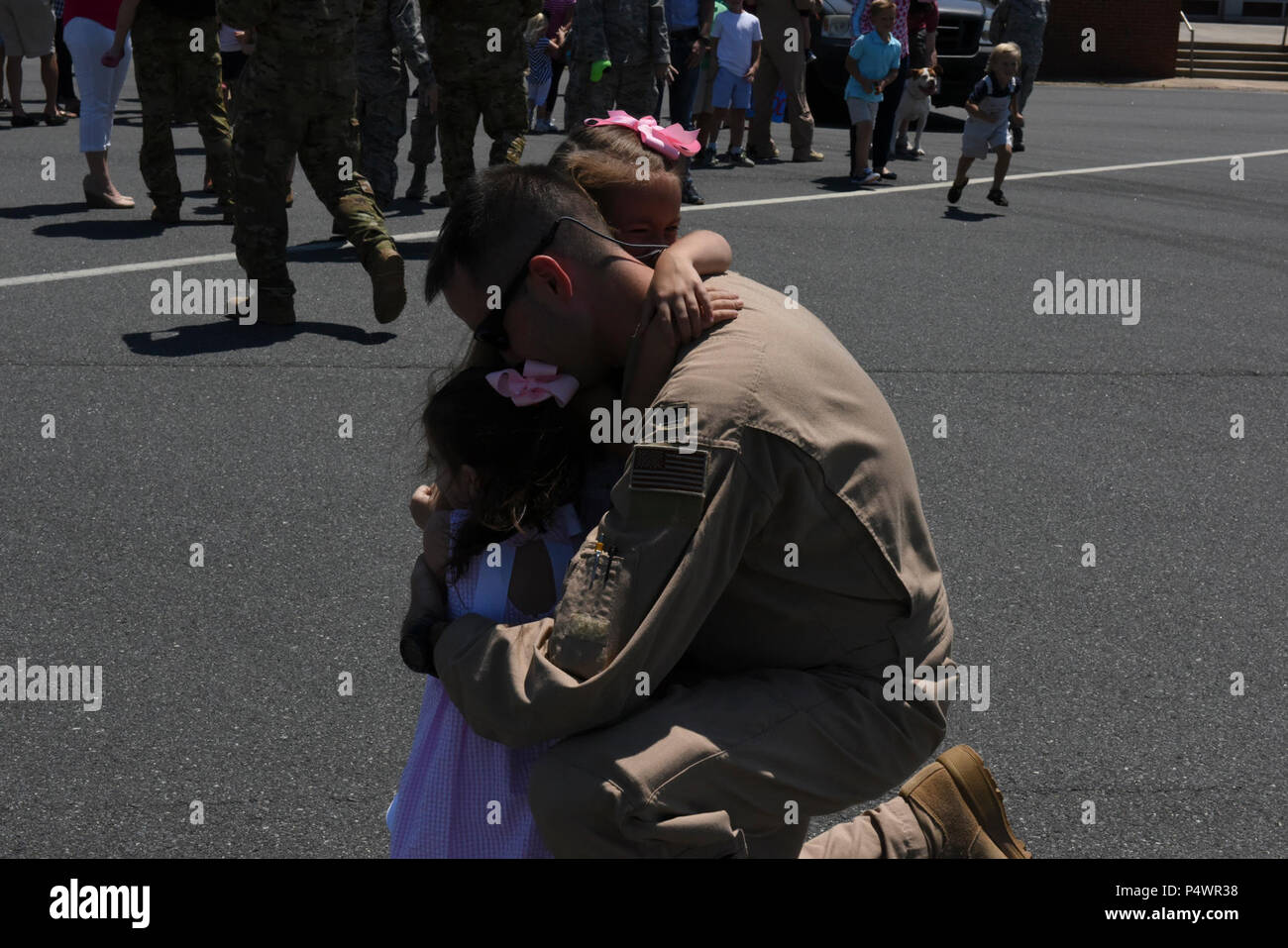 Une Caroline du capitaine de la Garde nationale aérienne longe ses deux filles pour la première fois à la suite d'un déploiement de trois mois en Asie du sud-ouest au nord Carolina Air National Guard Base, Charlotte Douglas International Airport, le 10 mai 2017. C'est le premier groupe de protection de l'air du déployeur pour revenir de la 145e Airlift Wing's mission à l'appui de l'opération Liberté's Sentinel. Banque D'Images