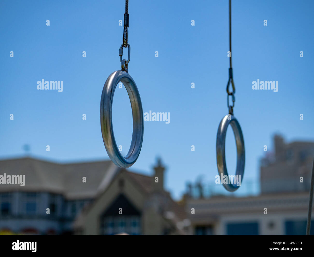 Anneaux de gymnastique en acier suspendu à un sport en plein air dans un quartier résidentiel Banque D'Images