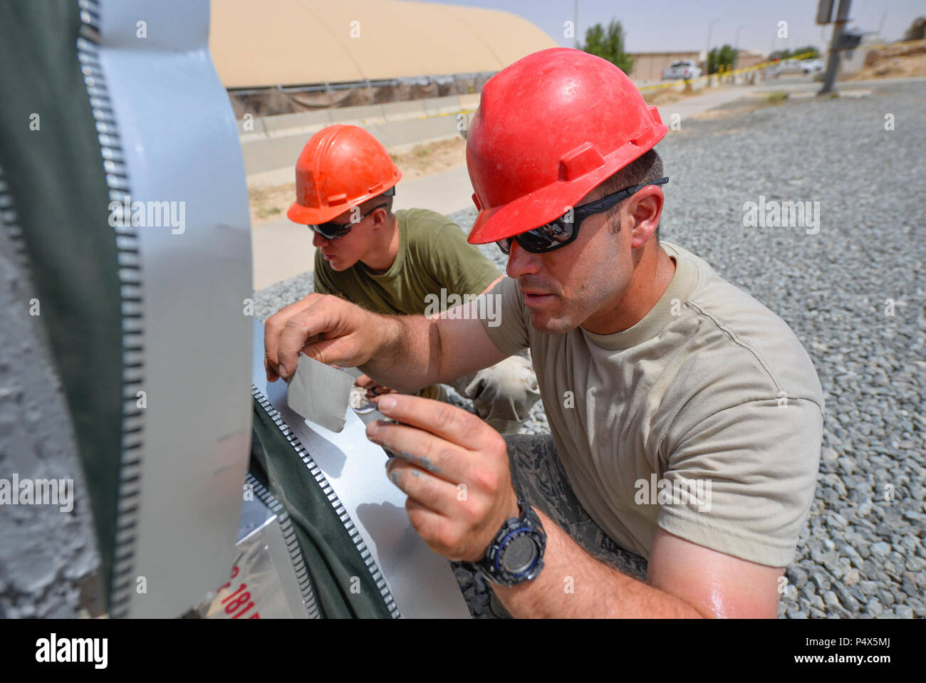 Tech. Le Sgt. Les moines de Travis, droite, un chauffage, ventilation et climatisation technicien et sous-officier responsable de l'installation HVAC avec le 407e Escadron de génie civil de la Force expéditionnaire du Canada, travaille avec le sergent du Corps des Marines des États-Unis. Jospeh Spore, un soudeur à l'Escadron de soutien de l'aile Marine 372, à l'étanchéité d'air connexions sur une unité de climatisation industrielle 4 mai 2017, dans le sud-ouest de l'Asie. Le nouveau système de refroidissement de l'air refroidi fournira à un bâtiment d'exploitation à la 407e groupe expéditionnaire aérienne à temps pour l'augmentation significative des températures estivales dans la région. Fusiliers marins et aviateurs partenaire fréquemment à Sharpe Banque D'Images