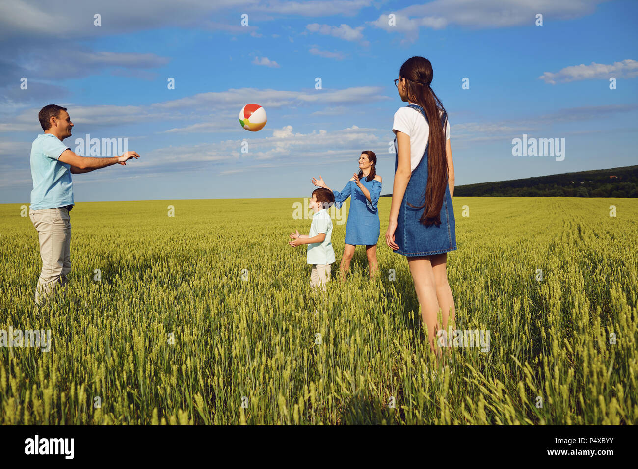 Happy Family Playing with ball dans le champ d'été Banque D'Images