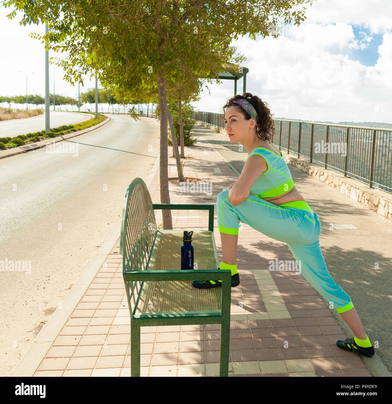 Girl doing Sports d'échauffement et d'étirement, de mettre un pied sur le banc Banque D'Images