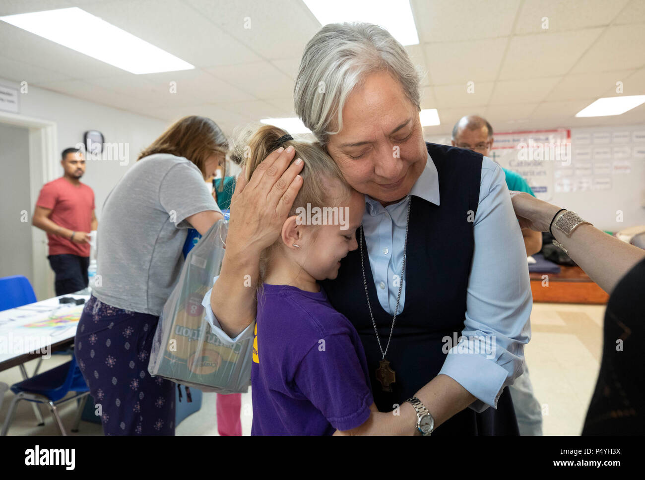 Sœur Norma Pimentel étreignant un bénévole en tant que familles immigrantes publié par le U.S. Immigration and Customs Enforcement (ICE) prendre un répit à l'abri de bienfaisance catholiques à McAllen TX en attendant la disposition de leurs affaires d'expulsion. Banque D'Images