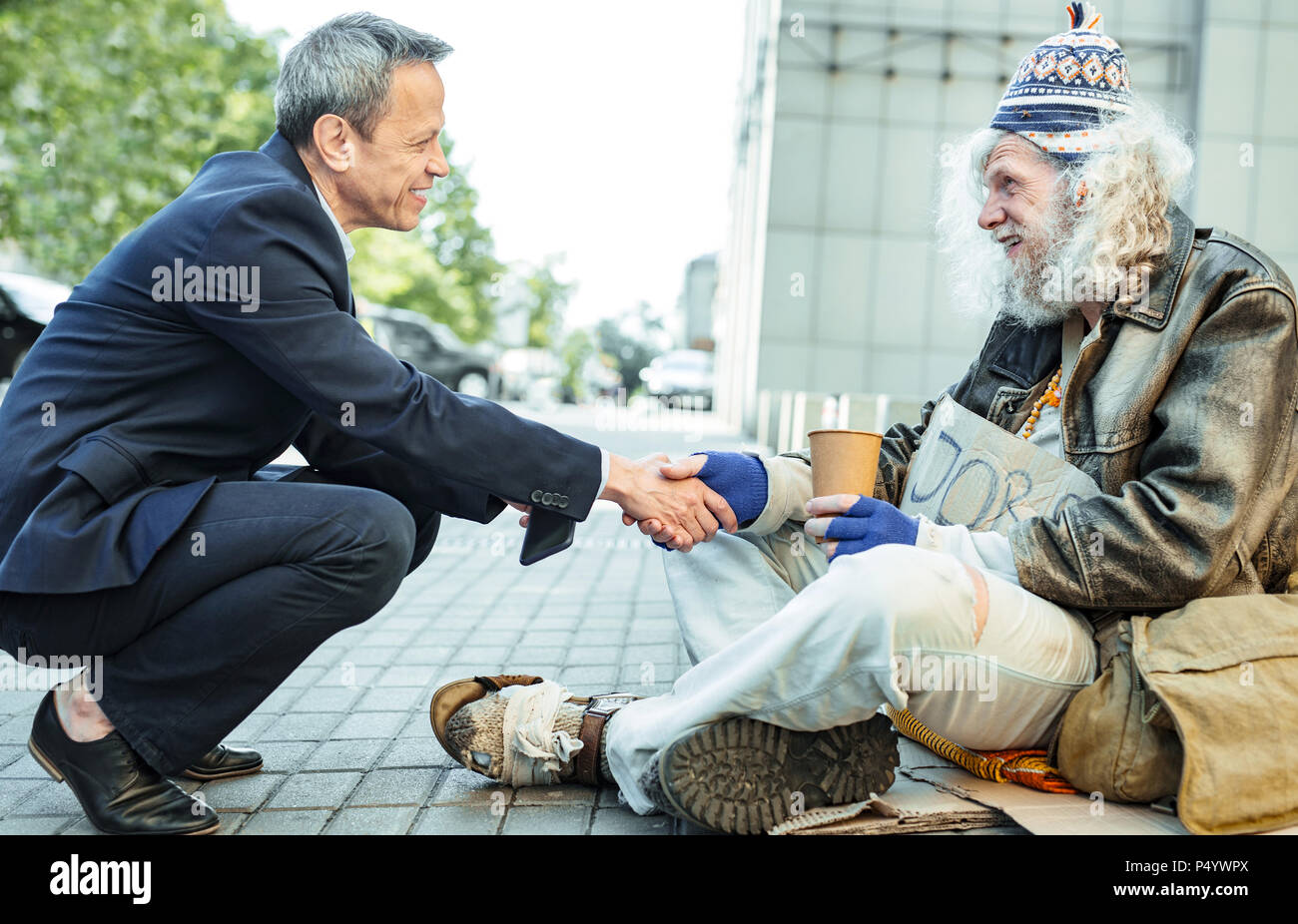 Smiling genre businessman shaking part d'homme affamé Banque D'Images