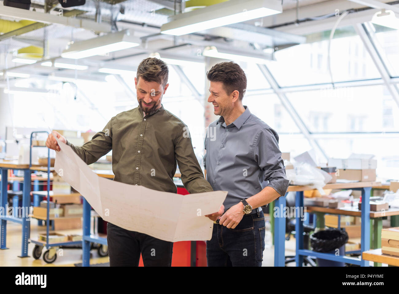 Deux hommes souriant à à plan en usine Banque D'Images
