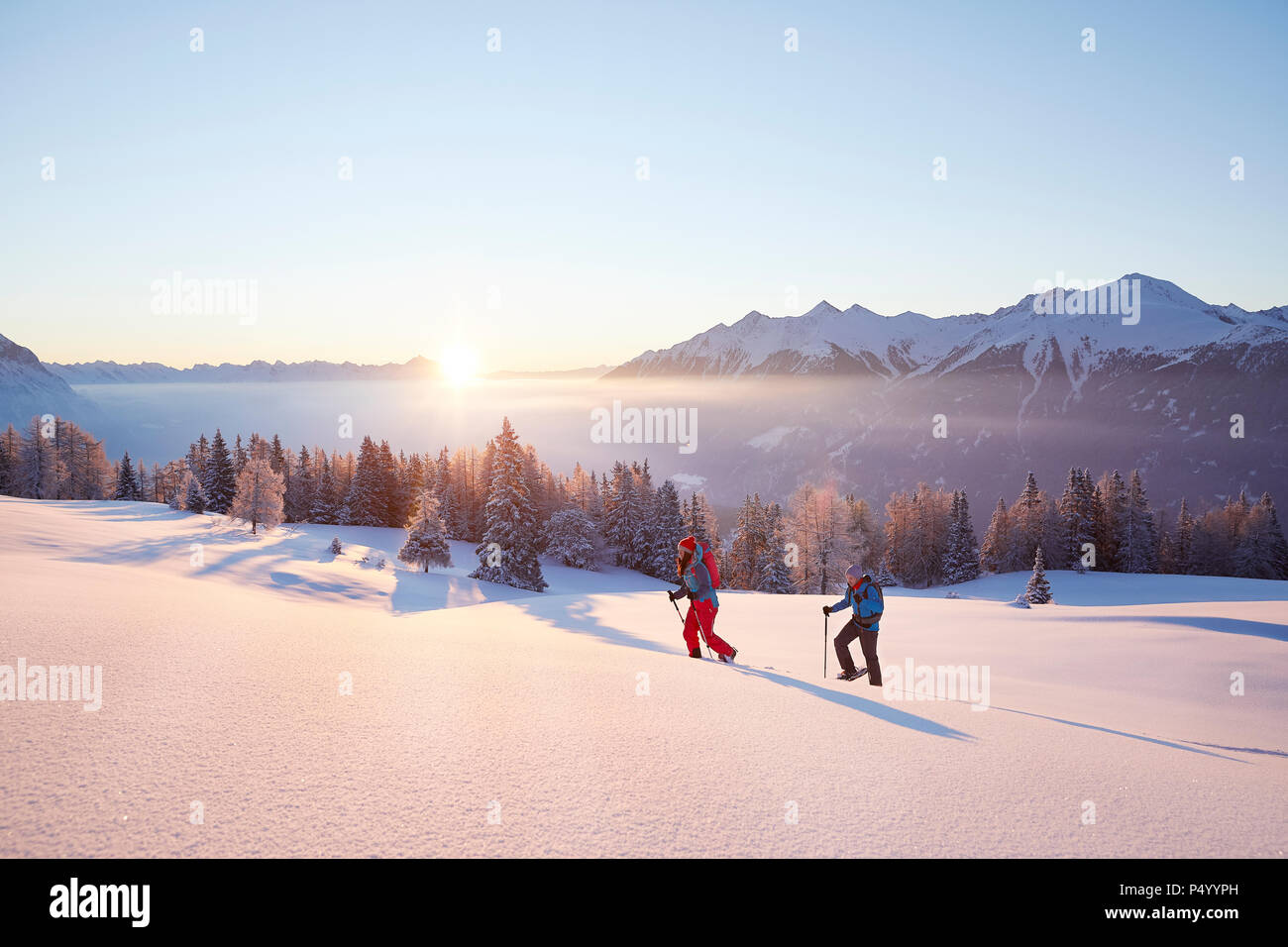 Autriche, Tyrol, randonneurs en raquettes au lever du soleil Banque D'Images