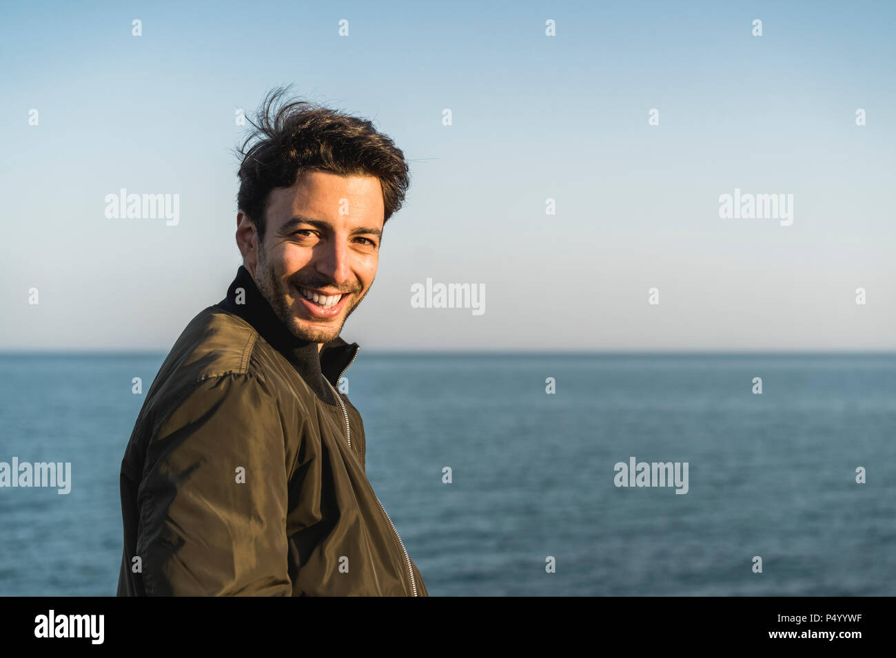 Portrait of smiling young man at the beach Banque D'Images