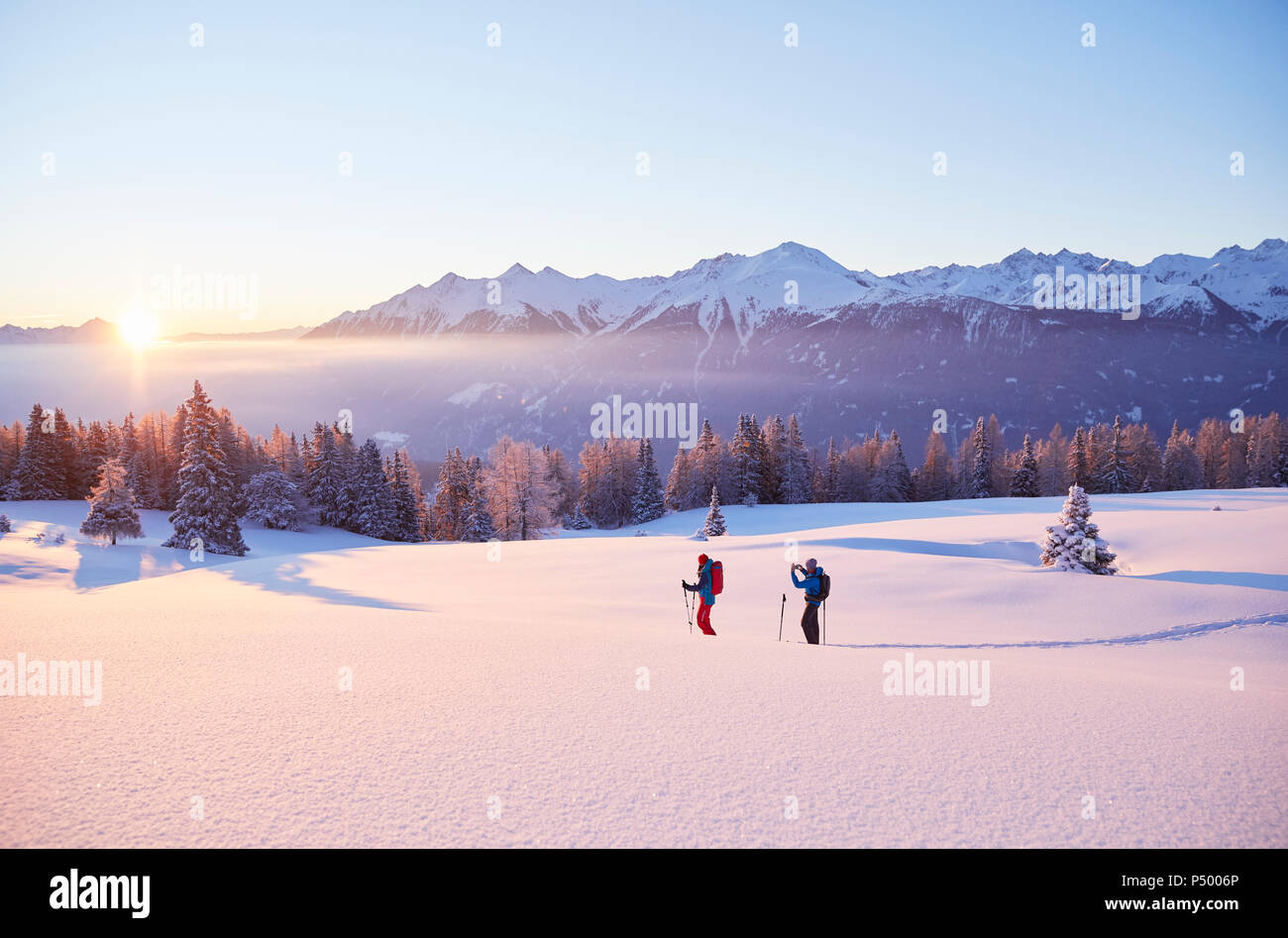 Autriche, Tyrol, couple de la raquette au lever du soleil Banque D'Images