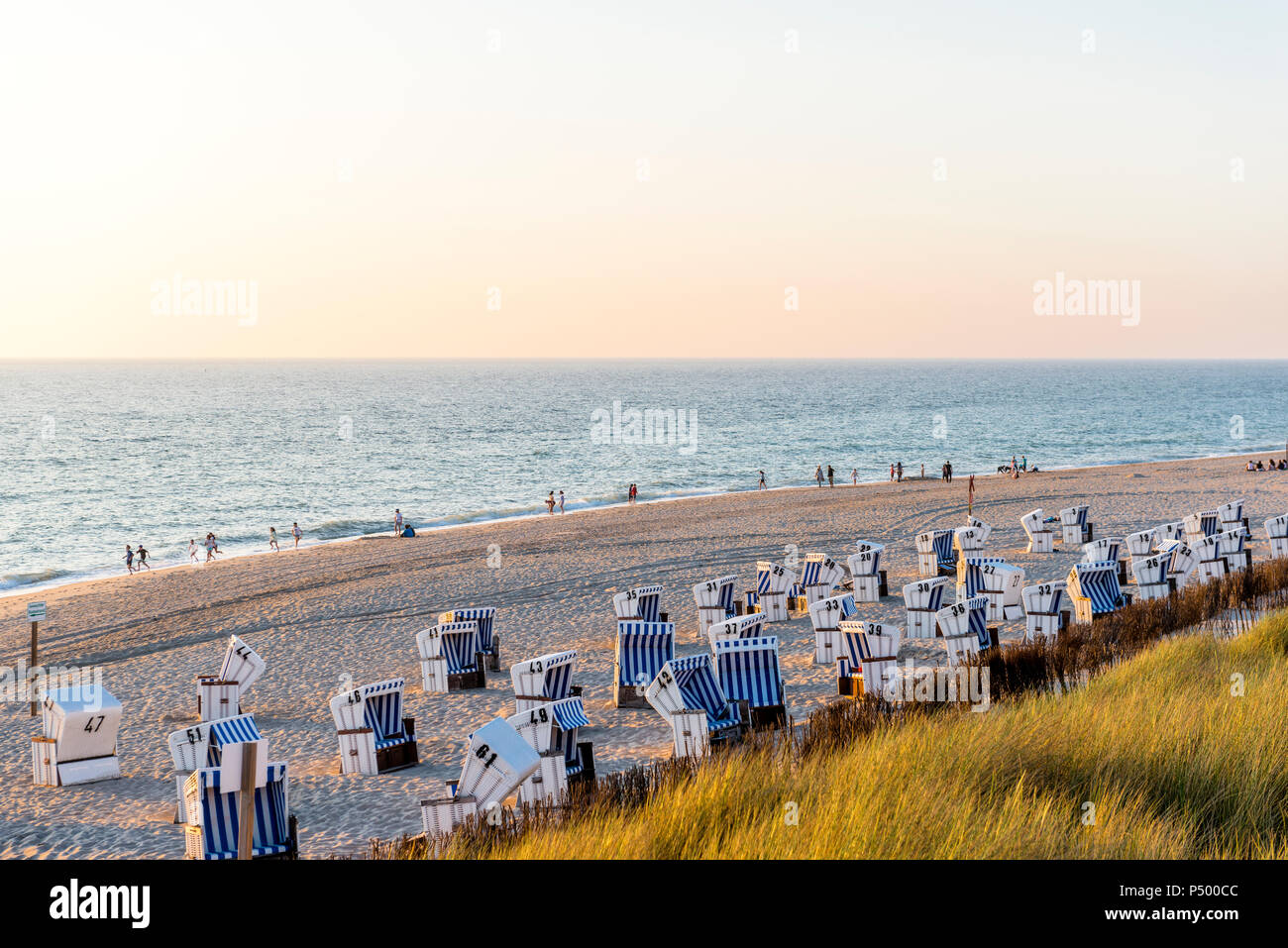 Allemagne, Schleswig-Holstein, Sylt, plage et à capuchon vide chaises de plage au coucher du soleil Banque D'Images