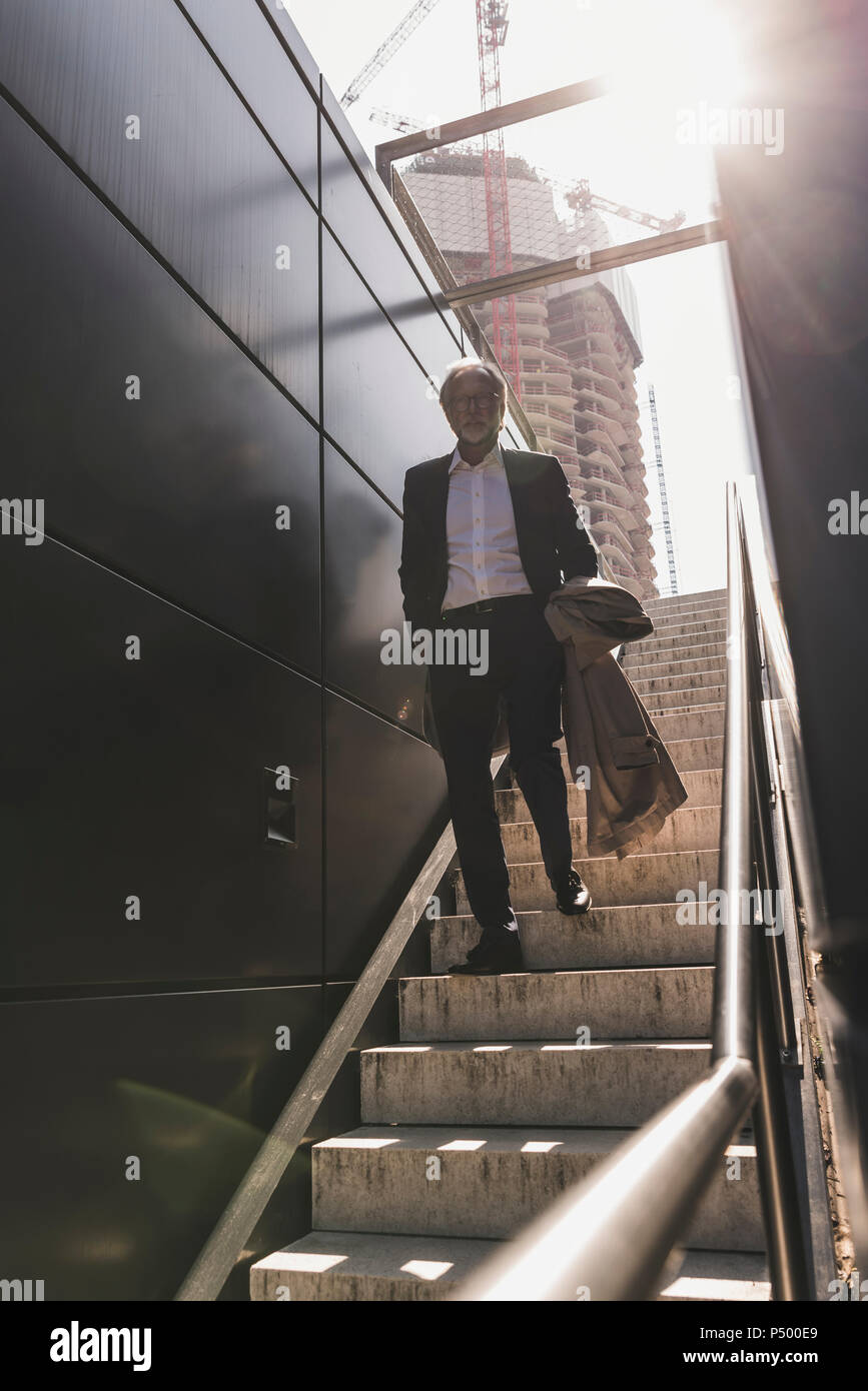 Mature businessman marche sur escalier dans la ville Banque D'Images