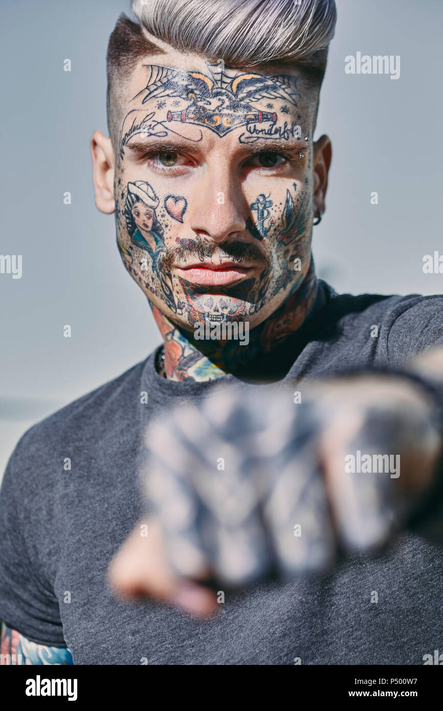 Portrait de jeune homme tatoué à l'extérieur de serrer son poing Banque D'Images