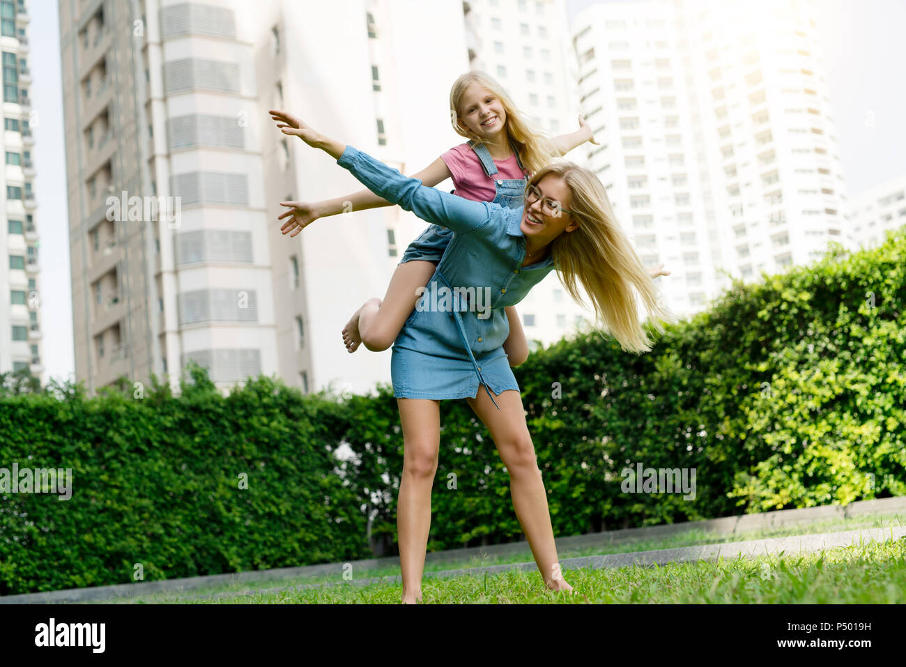 Happy mother and daughter having fun in urban city garden Banque D'Images