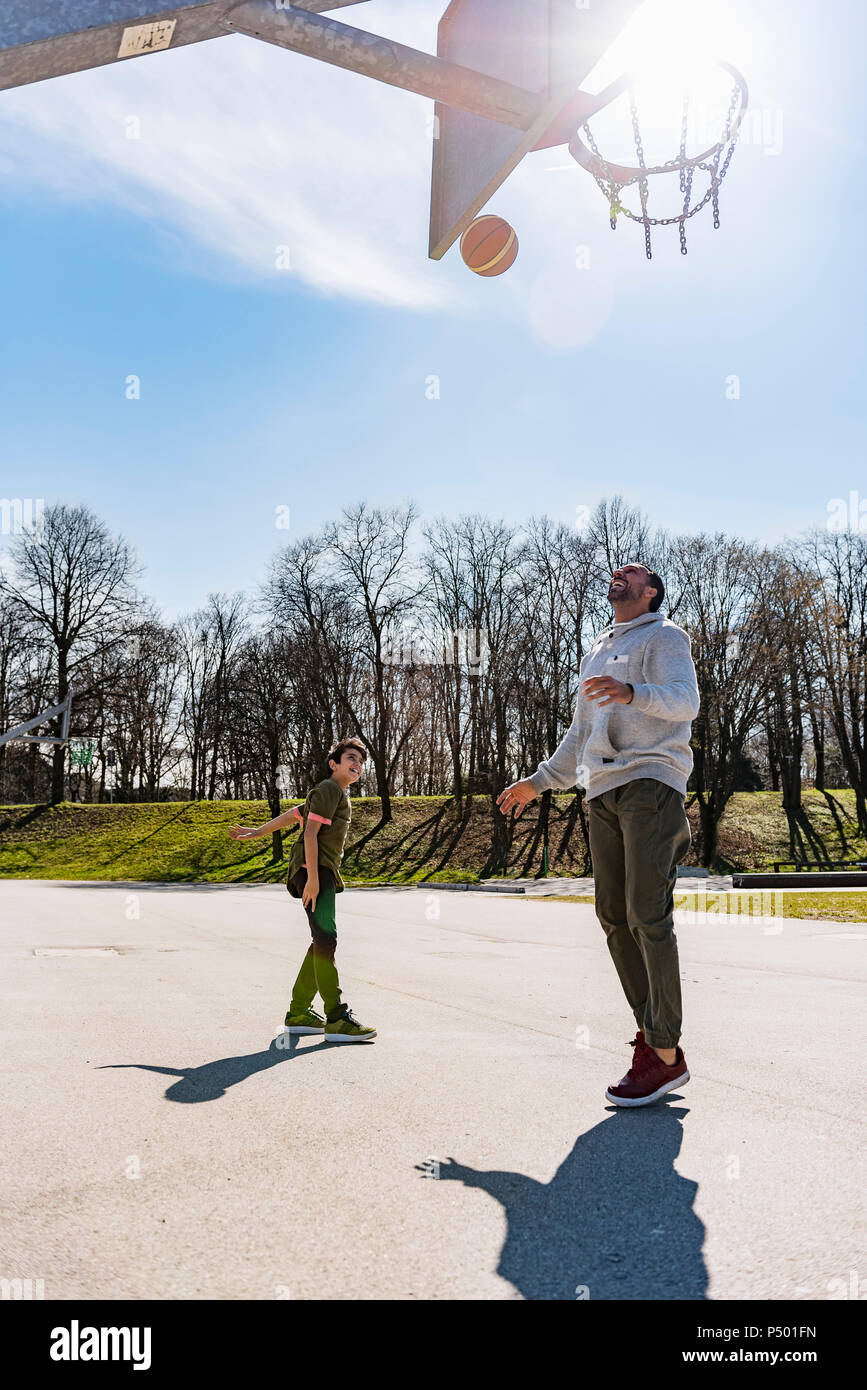 Père et fils jouer au basket-ball sur l'extérieur de la cour Banque D'Images Père et fils jouer au basket-ball sur l'extérieur de la cour Banque D'Images