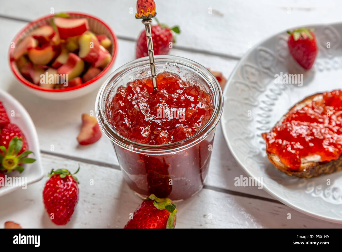Verre de confiture de rhubarbe fraise sur table du petit déjeuner Banque D'Images