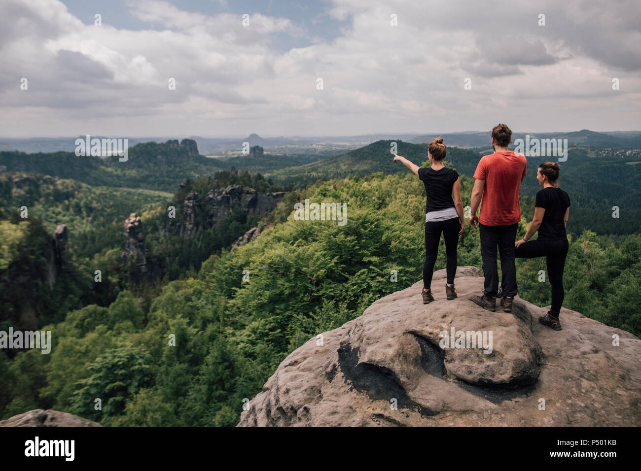 Allemagne, Saxe, des montagnes de grès de l'Elbe, les amis en randonnée debout sur rock Banque D'Images