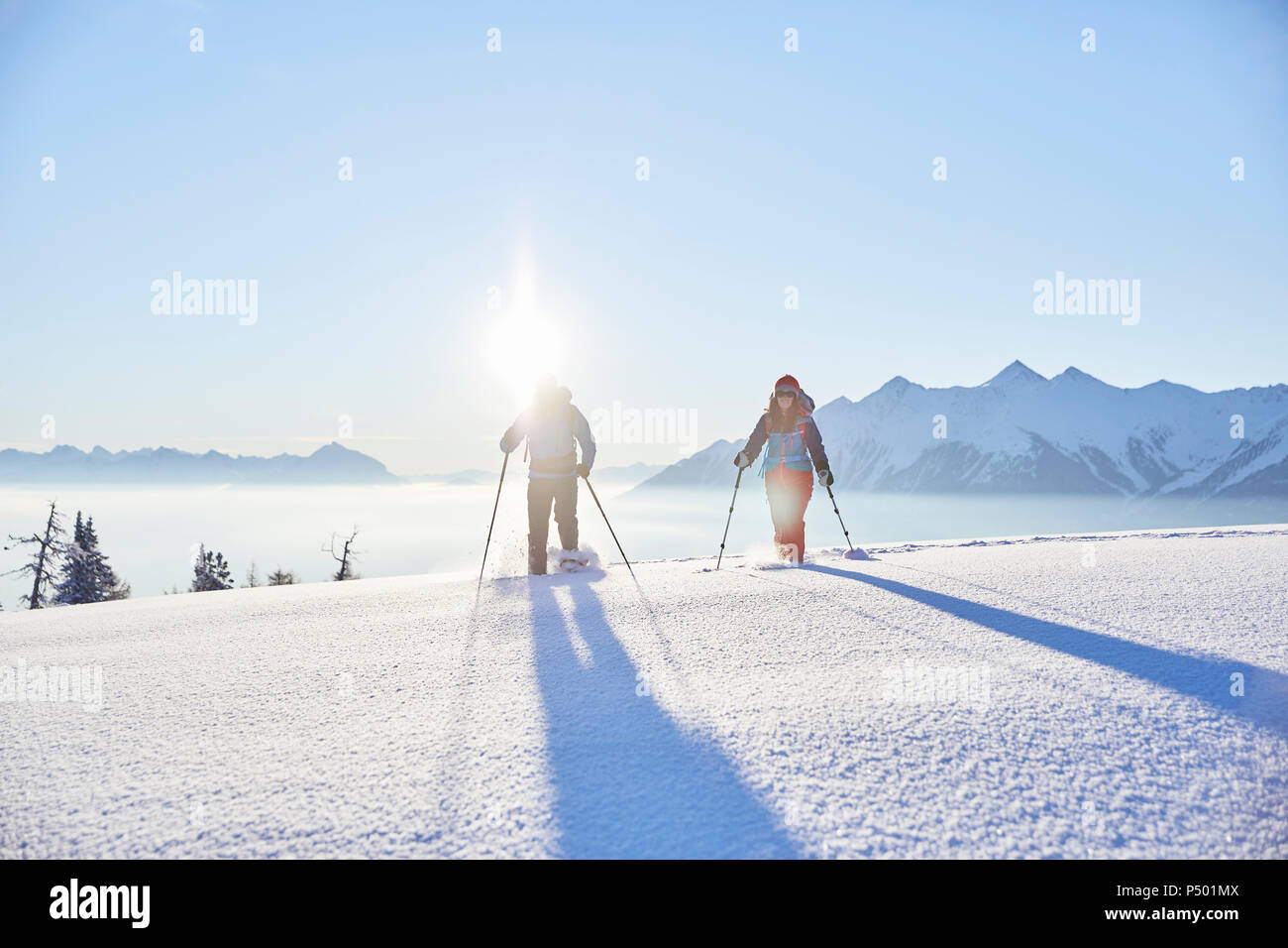 Autriche, Tyrol, randonneurs en raquettes au lever du soleil Banque D'Images