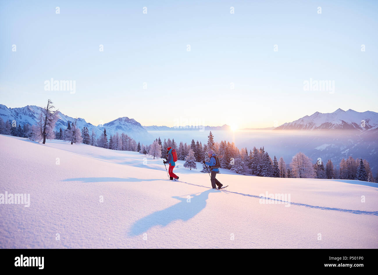 Autriche, Tyrol, randonneurs en raquettes au lever du soleil Banque D'Images