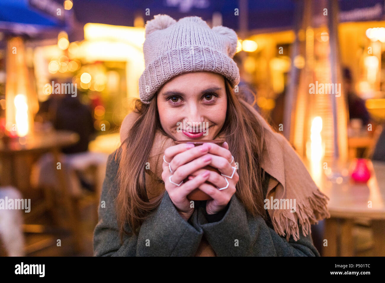Contenu Portrait de jeune femme à boire le vin chaud au marché de Noël Banque D'Images