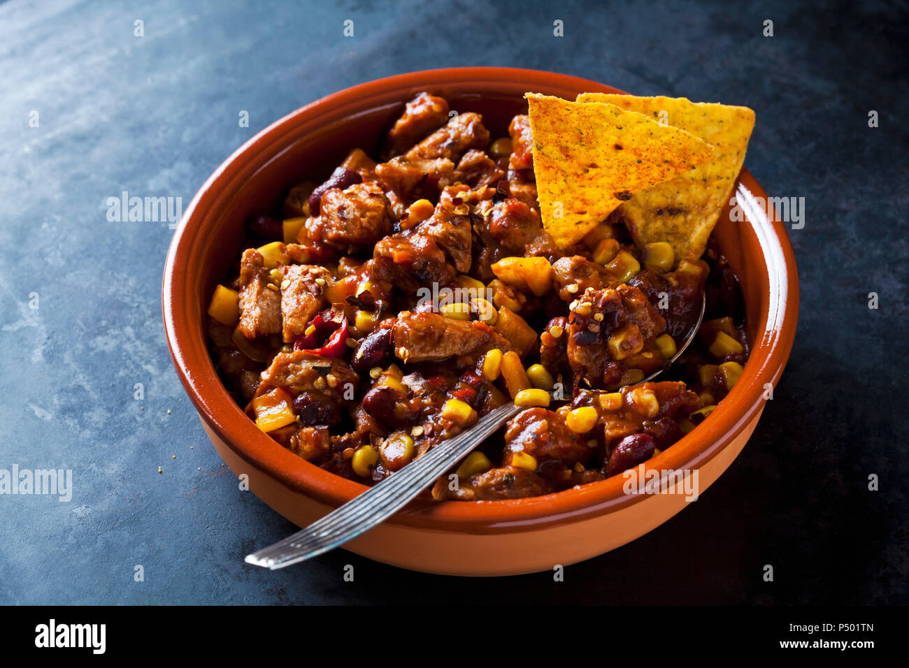 Chili végétarien au soja viande coupée en lanières et les croustilles au maïs dans le plat en faïence Banque D'Images