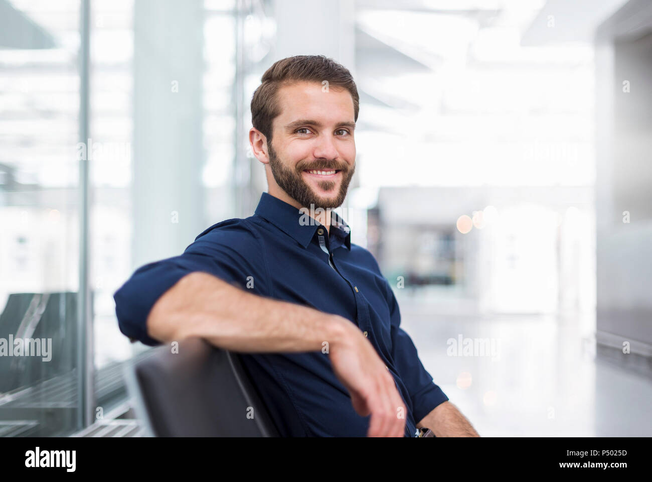 Portrait of a young businessman sitting in waiting area Banque D'Images