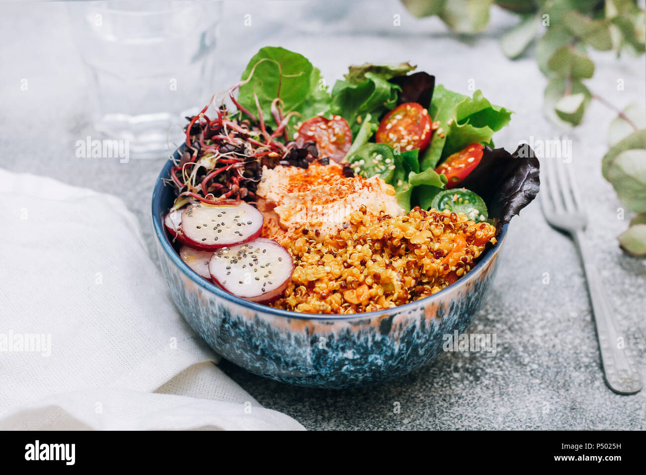 Bol bouddha vegan d'hummus, quinoa au curry, la laitue, les choux vert et rouge, tomates cerise, radis tranchés et les graines de pavot et de sésame Banque D'Images Bol bouddha vegan d'hummus, quinoa au curry, la laitue, les choux vert et rouge, tomates cerise, radis tranchés et les graines de pavot et de sésame Banque D'Images