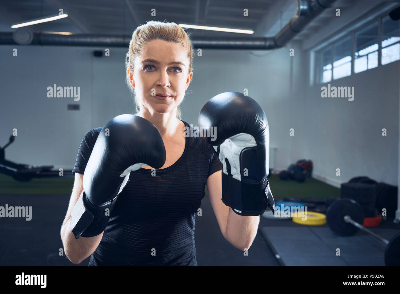 Portrait of woman practicing boxing at gym Banque D'Images