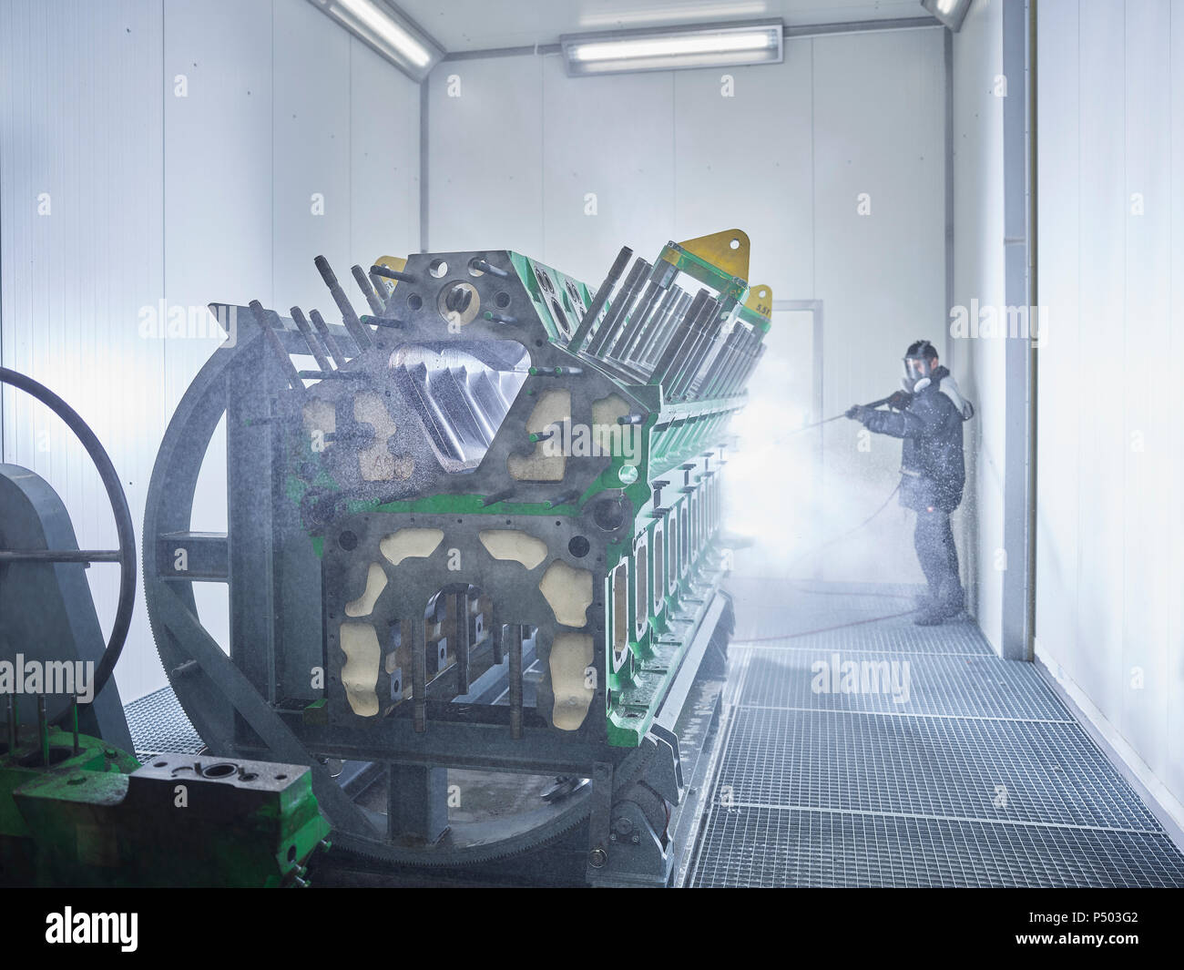 Nettoyage travailleur bloc moteur dans la baie de lavage Photo Stock - Alamy