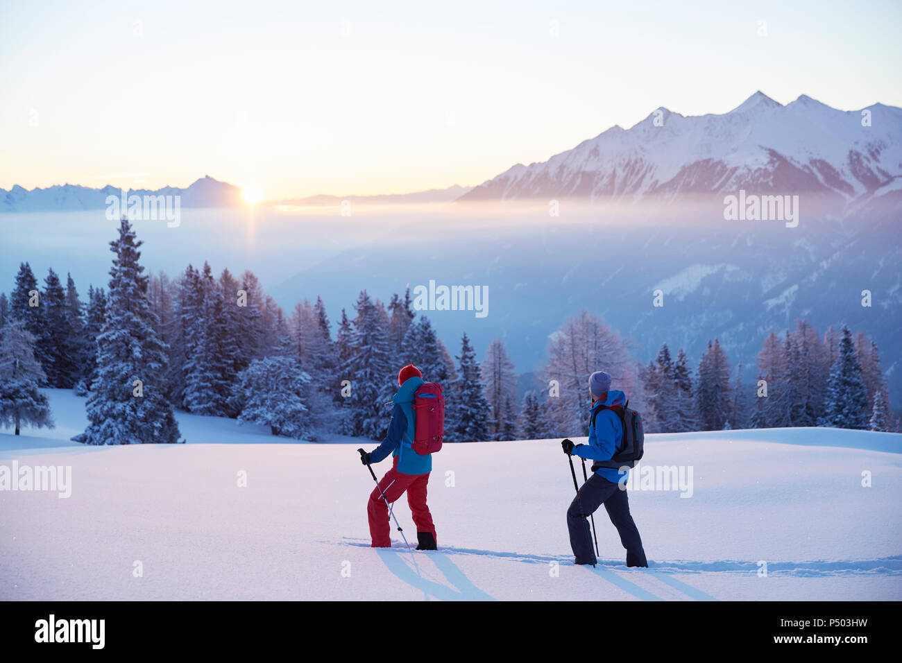 Autriche, Tyrol, randonneurs en raquettes au lever du soleil Banque D'Images
