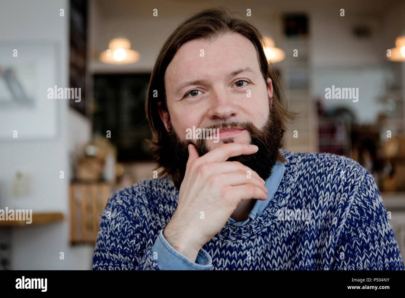 Homme avec barbe, assis dans un café, portrait Banque D'Images