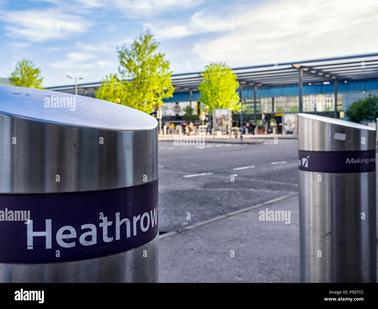 AÉROPORT DE HEATHROW, LONDRES - 17 MAI 2018 : bollards de sécurité à l'extérieur du bâtiment du terminal 3 avec bâtiment du terminal défoqué en arrière-plan Banque D'Images