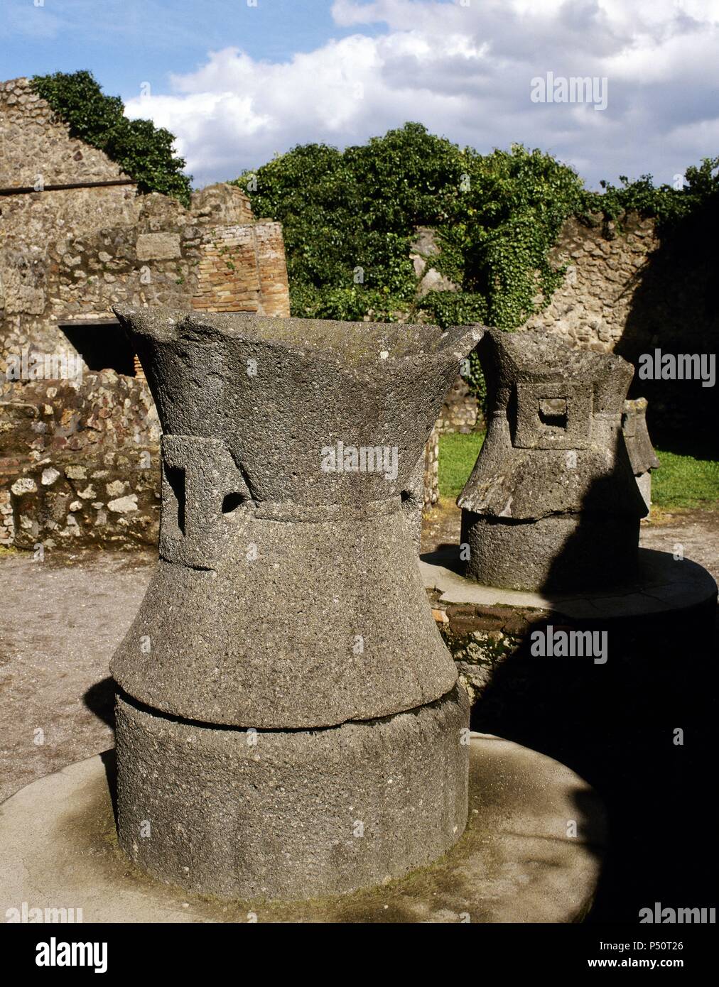 Pompéi. Ancienne ville romaine. Boulangerie de Modesto. Meules faites de lave basaltique, tirée par l'âne pour moudre le grain. L'Italie. Banque D'Images