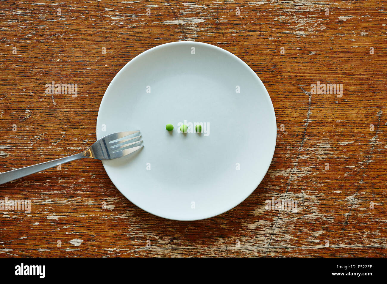 Trois petits pois sur la plaque prête à être mangée la malnutrition Banque D'Images