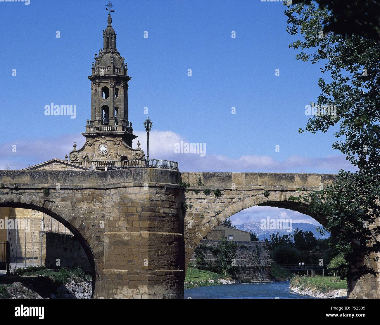 LA RIOJA. CUZCURRITA DEL RIO TIRON. Vista parcial del puente de piedra sobre el RIO TIRON. Al fondo destaca la torre barroca de la Iglesia Parroquial, levantada en el siglo XVIII. Comarca de la Rioja Alta. España. Banque D'Images