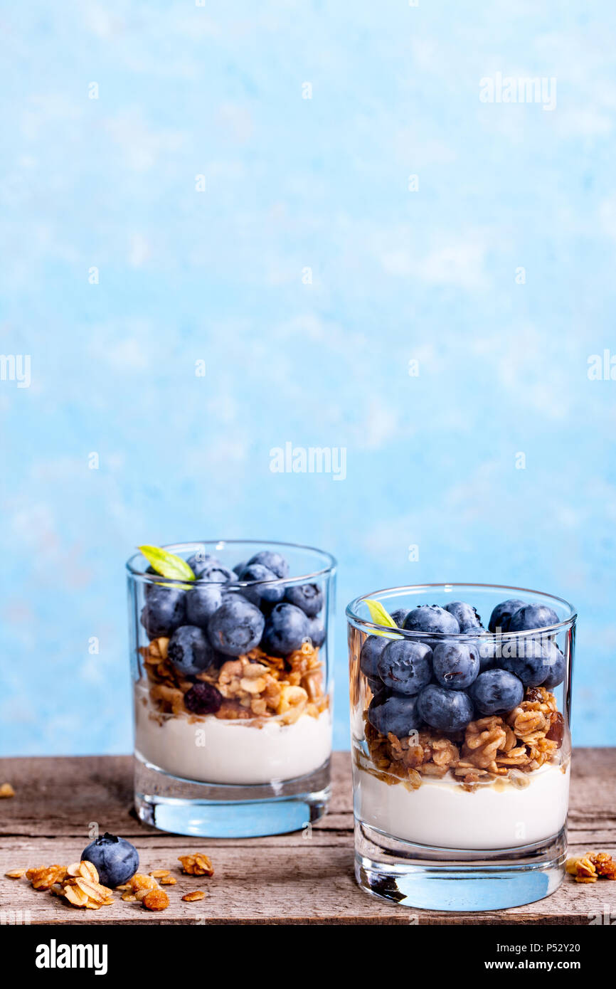 Blueberry dessert, gâteau au fromage, bagatelle, du muesli dans un verre sur une table en bois vintage avec des fissures. Banque D'Images