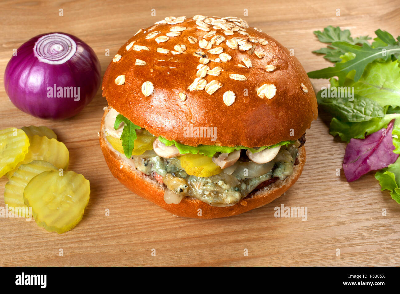 Hamburger fait maison avec sauce au fromage bleu sur une table en bois Banque D'Images