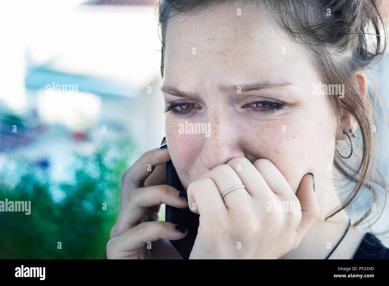 Une jeune fille de parler par téléphone l'article ayant de mauvaises nouvelles, choqué, triste. pleurer. Banque D'Images
