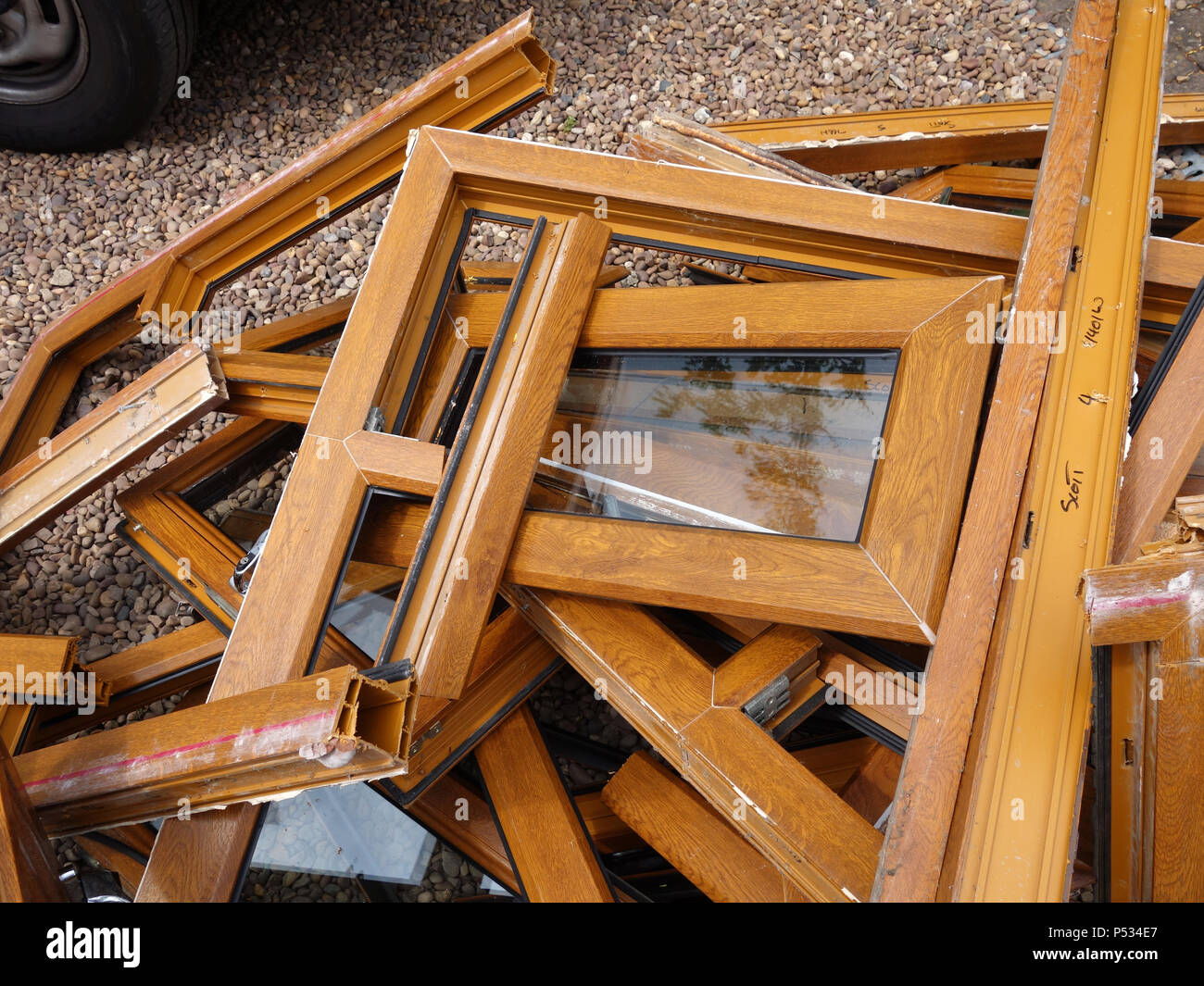 Une pile de bois en plastique mis au rebut des cadres de fenêtre ex effet étant remplacé par un parquet en chêne. Plus plastique et déchets de verre destinés à l'élimination en décharge Banque D'Images